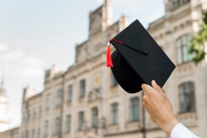 graduation-concept-with-student-holding-hat_23-2148201873